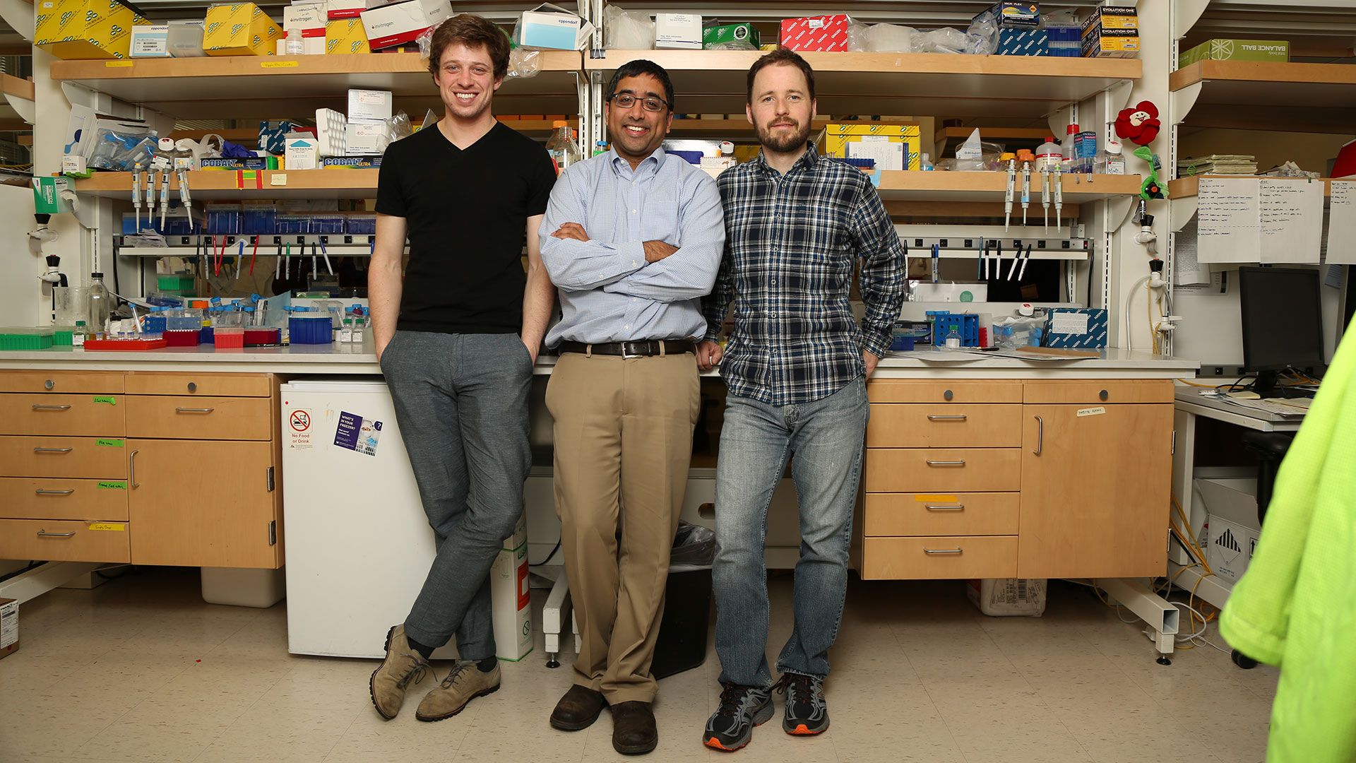 Three male researchers, one of them Jay Shendure, leaning against a table in a lab