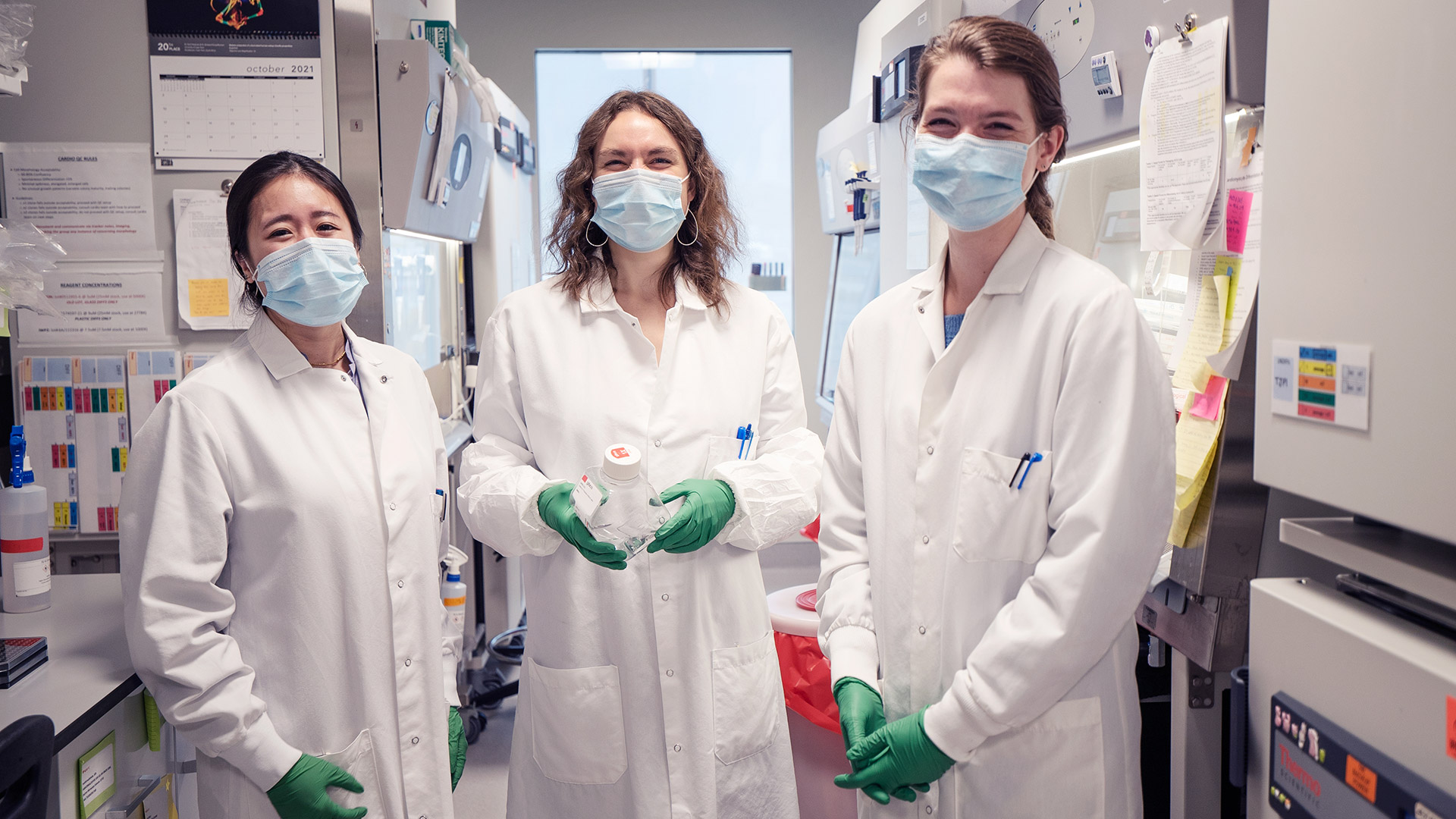 Three female researchers in white lab coats