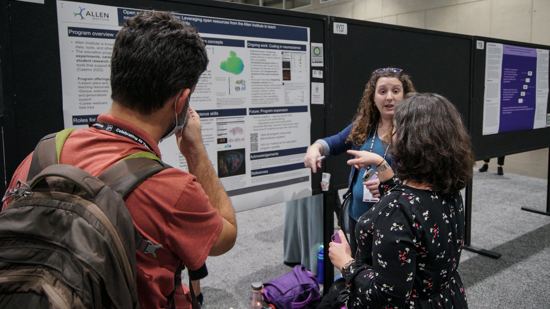 Kaitlyn Casimo speaking to attendees at SfN 2022 poster session