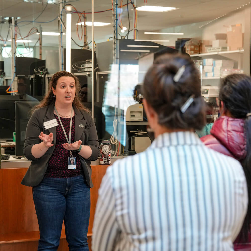 Teacher on an education tour at the Allen Institute in front of a lab