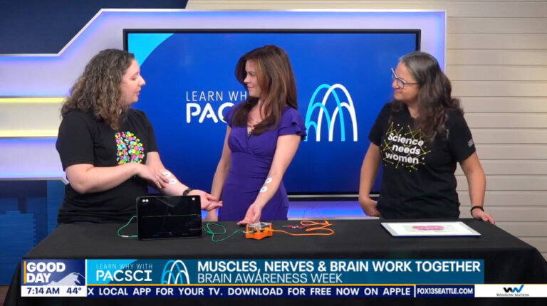 A woman on a TV set explaining neuroscience to a television presenter