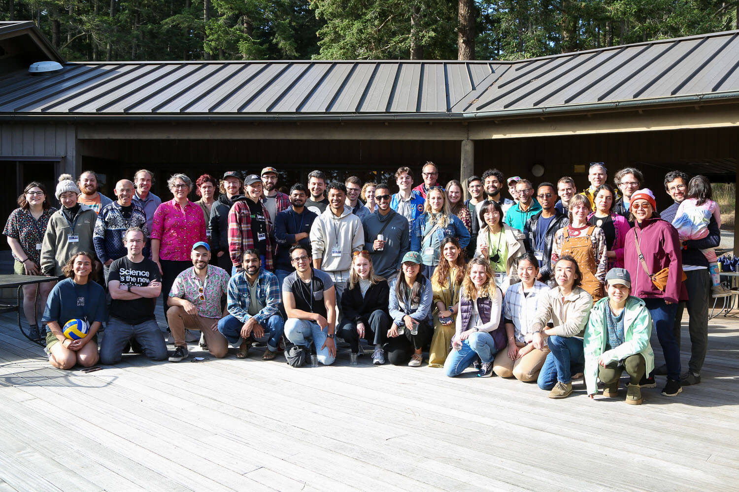 Students from the 2024 Summer Workshop on the Dynamic Brain posing in a group photo on a sunny deck