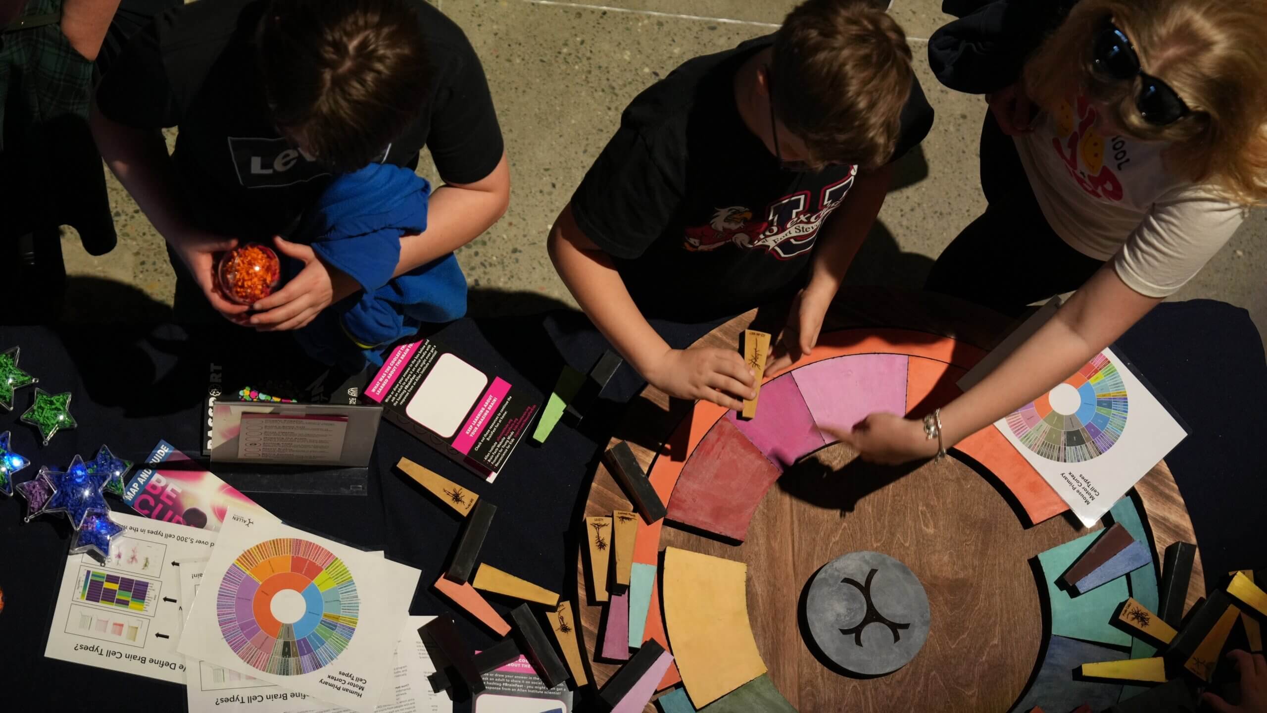 View looking down on an activity at BrainFest 2024 in which visitors are assembling a giant wooden puzzle